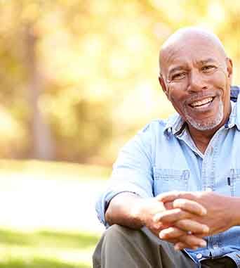 Senior man smiling with hands folded