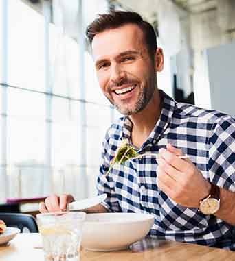 Man sitting at table eating a salad