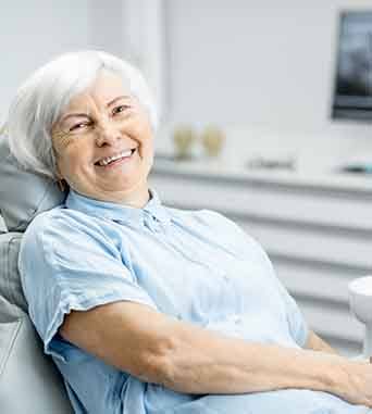Senior woman sitting in dental chair smiling