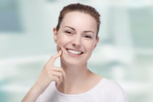 Smiling young woman touching her cheek
