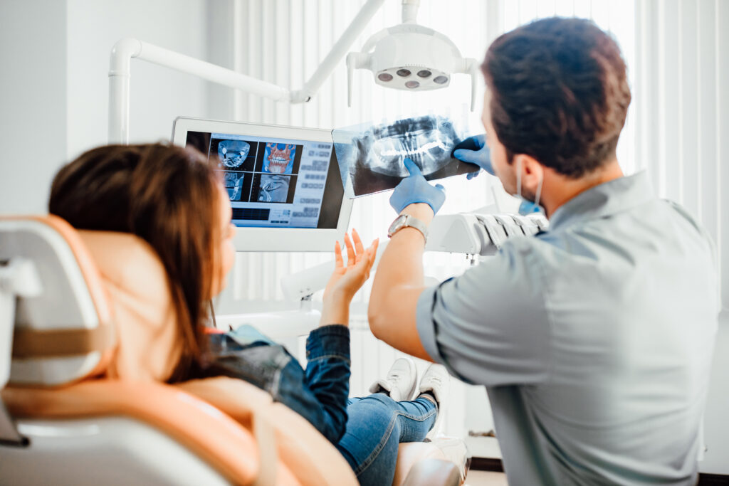 An oral surgeon showing a patient her dental X-rays