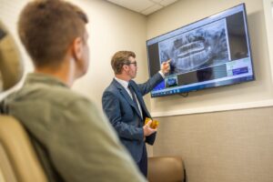 Dr. Michael Chambers reviews a panoramic x-ray on a screen with a patient during a consultation